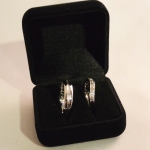 Voici une paire d'alliances en or blanc. Celle de madame est couverte de petits diamants et avec une courbe pour être facilement porté avec la bague de fiançailles. Pour monsieur nous avons une alliance rainurée avec une texture brute dans celle ci.