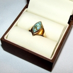 Bague or jaune avec, en solitaire, une turquoise en forme de navette incluse de pyrite. Réalisée avec l'or d'anciens bijoux.