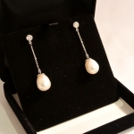 Voici une paire de boucles d'oreilles or blanc, diamants et perles.