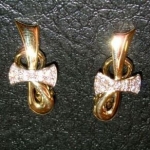 Paire de boucles d'oreilles en or jaune avec le nœud en or blanc et diamants.