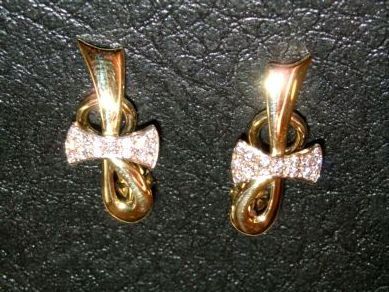 Paire de boucles d'oreilles en or jaune avec le nœud en or blanc et diamants.