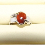 Paire de petites mains stylisées en or blanc tenant la pierre, bague réalisée sur base du croquis du client.