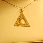 Triangle or jaune avec une petite lune en son centre saupoudré d'étoiles avec diamants.