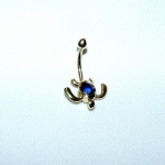 Piercing de nombril représentant une tortue marine en or jaune avec un saphir bleu.
