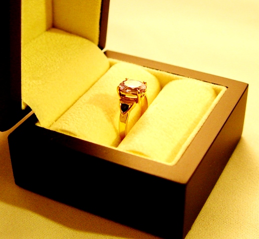 Bague or jaune avec un quartz rose flanqué de deux saphirs bleus taille brillant dans des sertissures ogivales.