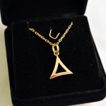 Un pendentif en or jaune, un triangle courbe.