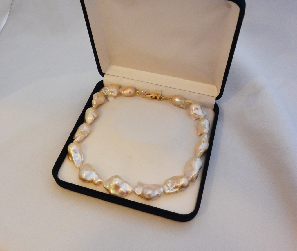 Voici une collier de perles baroques avec un mousqueton or jaune.