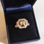 Voici une bague or blanc à l'ancienne sertie d'un diamant de 1.01 Ct en sont centre et de 22 petits dans l'entourage et les palmettes.