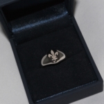 Voici une chevalière or blanc gravée d'une fleure de Lys.