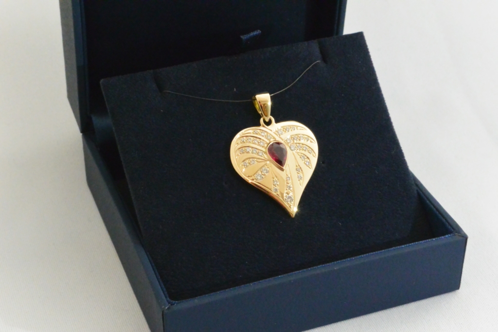 Voici un pendentif or jaune, rubis et diamants entre la feuille et le cœur ainsi que les croquis du projets.