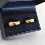 Voici une paire d'alliance or jaune avec une gravure extérieur, un petit diamant en son centre chez madame. L'idée ici est de symbolisé deux chemins différant qui se rencontrent.